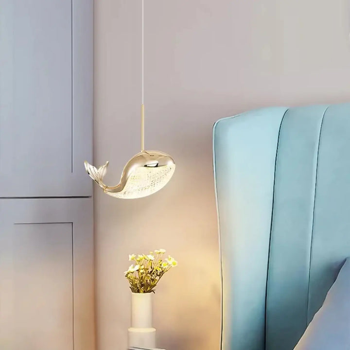 Suspension luminaire aquara en forme de baleine dorée avec corps translucide texturé et nageoire caudale délicate