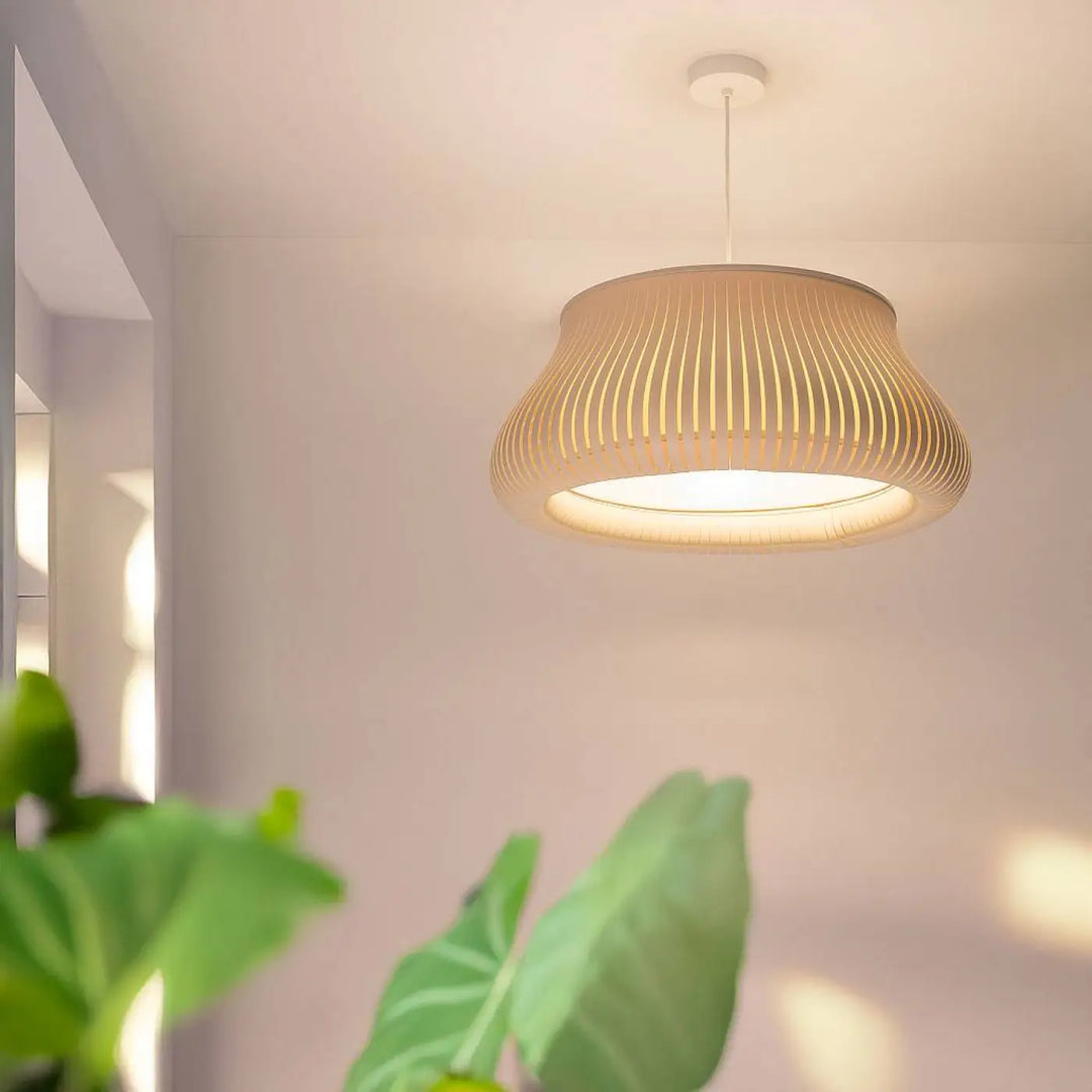 Suspension luminaire oblo beige en papier côtelé avec une lumière chaude diffusée idéal pour l’éclairage intérieur
