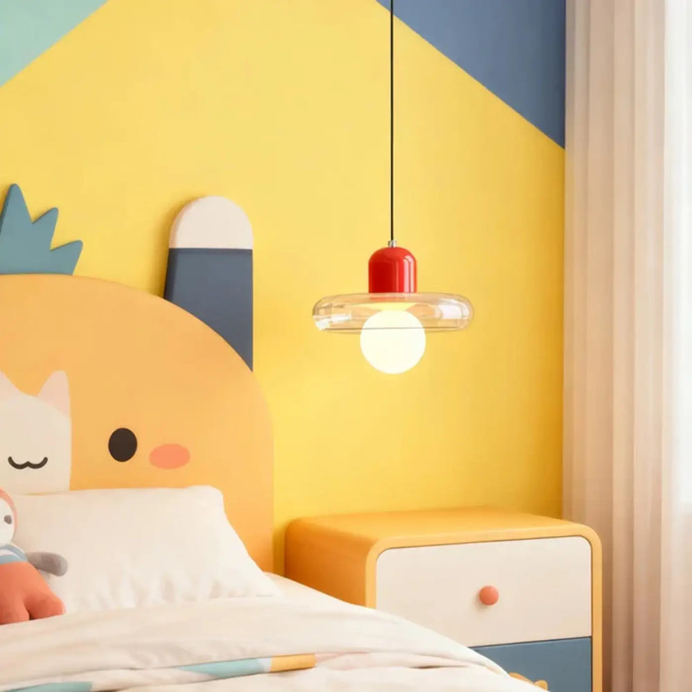 Suspension luminaire dopamine avec abat-jour cylindrique rouge et verre transparent suspendue au-dessus du lit