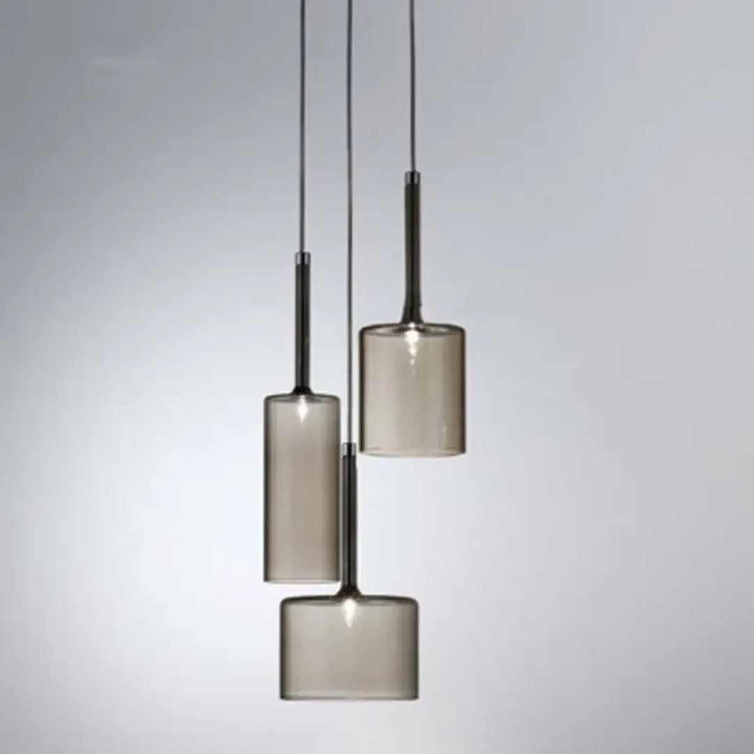 Suspension luminaire cylis avec abat jours cylindriques en verre fumé et fixations métalliques noires modernes et minimalistes