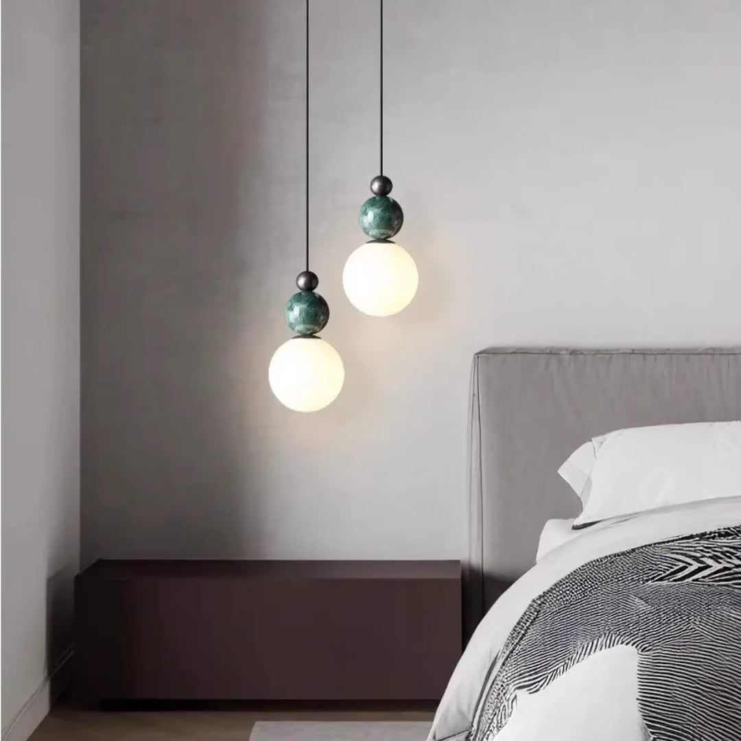 Suspension luminaire eluna avec design moderne, abat-jour sphérique vert mat et globe en verre dépoli au-dessus du lit