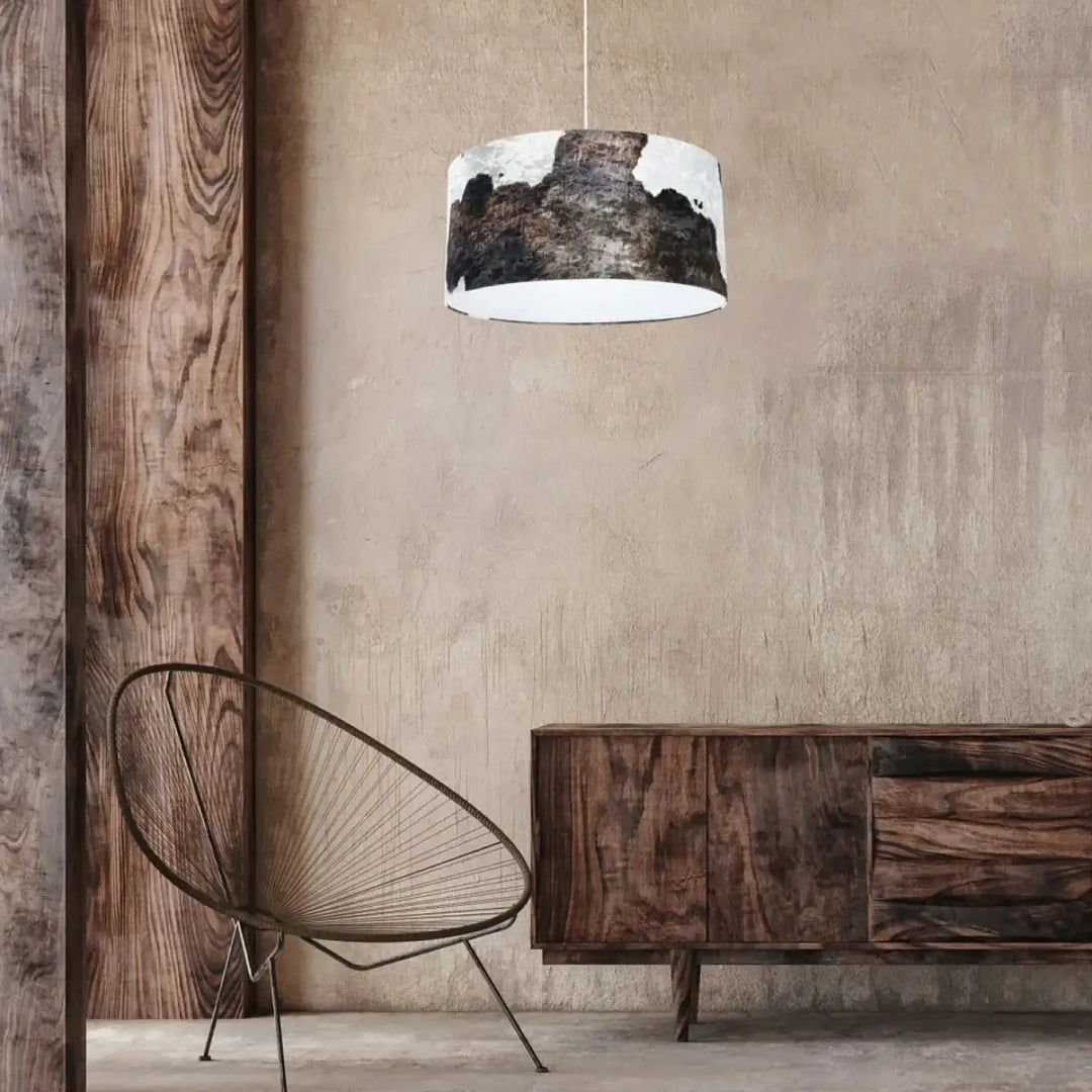 Suspension luminaire cylindrique marron blanc avec intérieur blanc et motif peau de vache noir et blanc suspendu par cordon fin