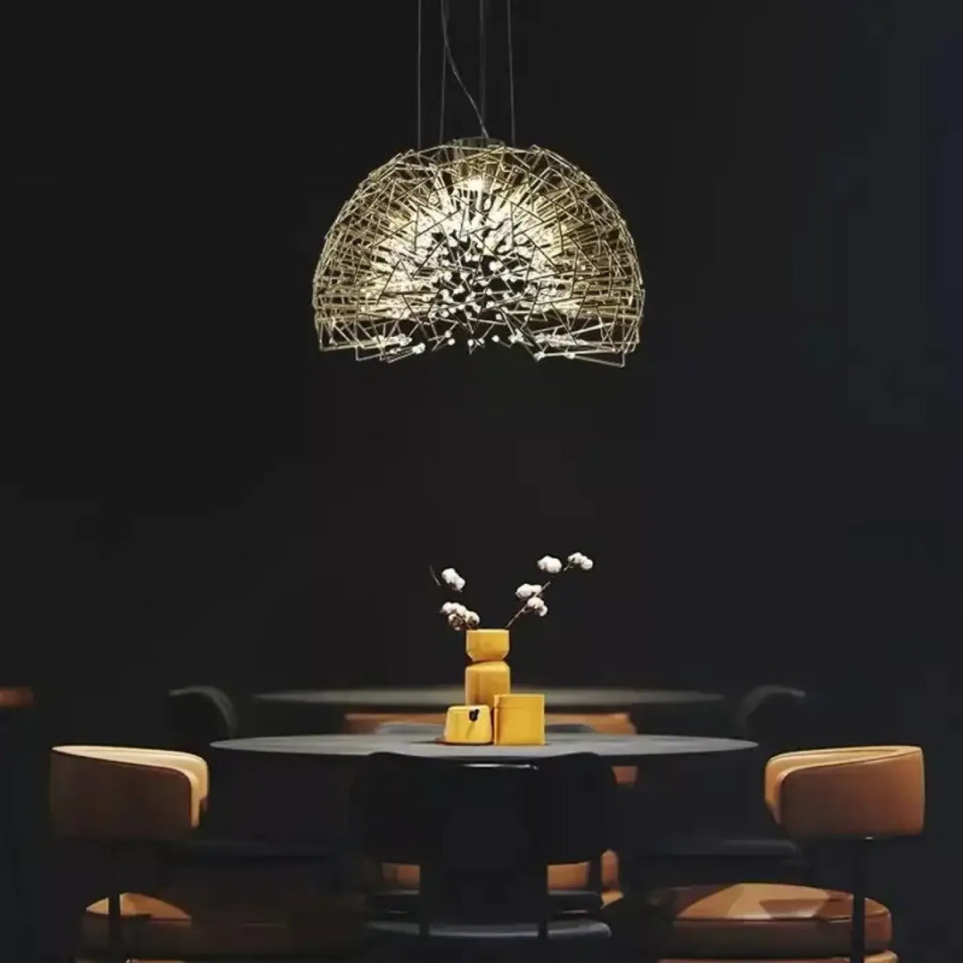 Suspension luminaire texia dorée en fil métallique avec design sphérique complexe suspendue au-dessus d’une table sombre