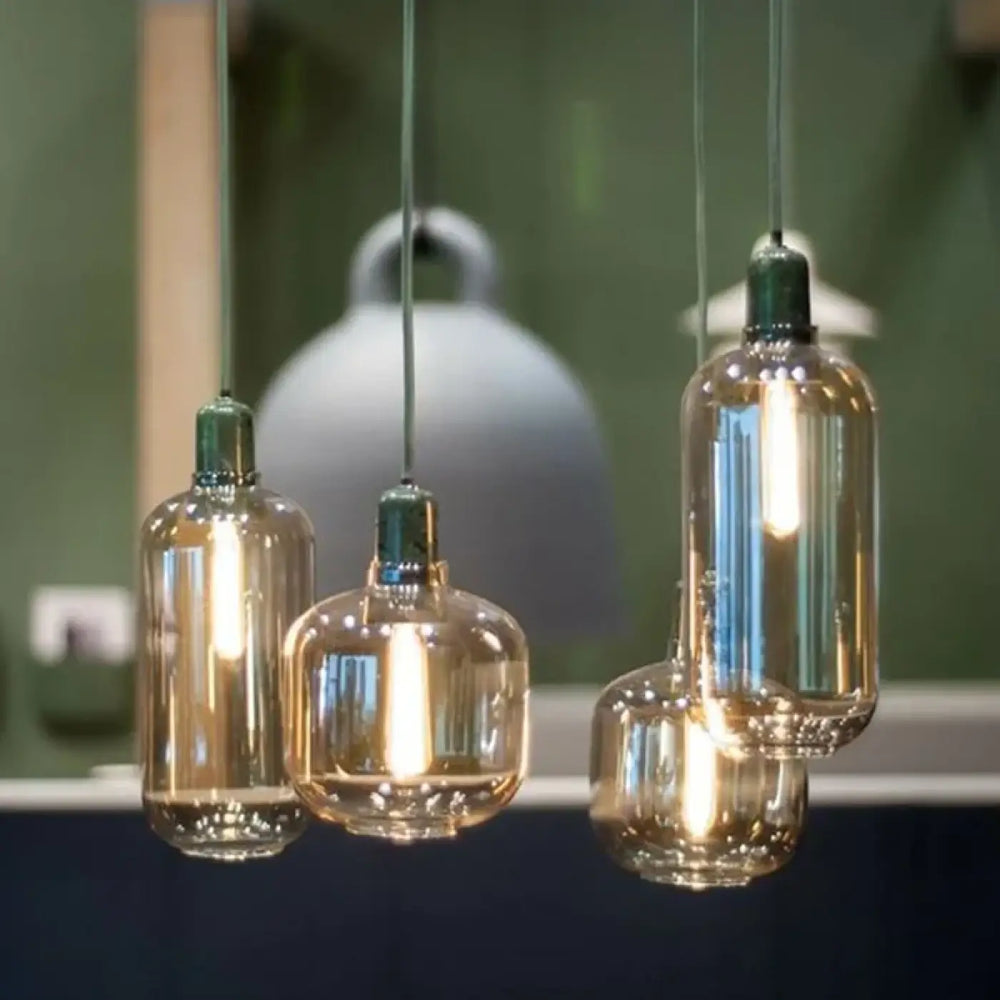 Suspension luminaire hyalis en verre teinté ambre avec formes arrondies et dessus métallique vert à filament visible