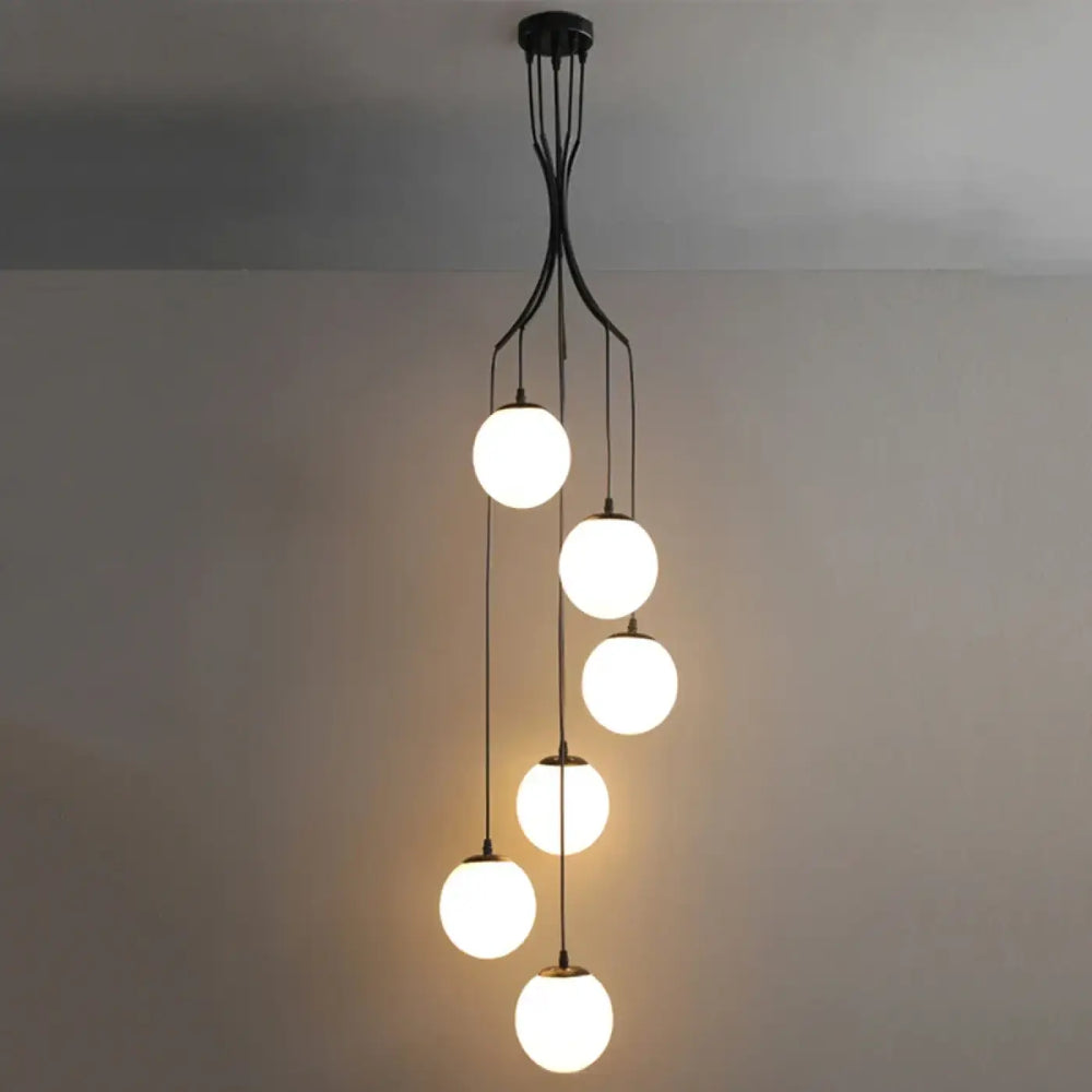 Suspension luminaire umami en métal noir moderne avec cinq globes en verre blanc lumineux en cascade