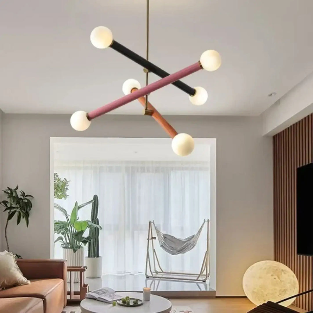 Suspension luminaire tsara avec tiges géométriques noires, roses et bois tenant des ampoules sphériques pour lumière diffuse