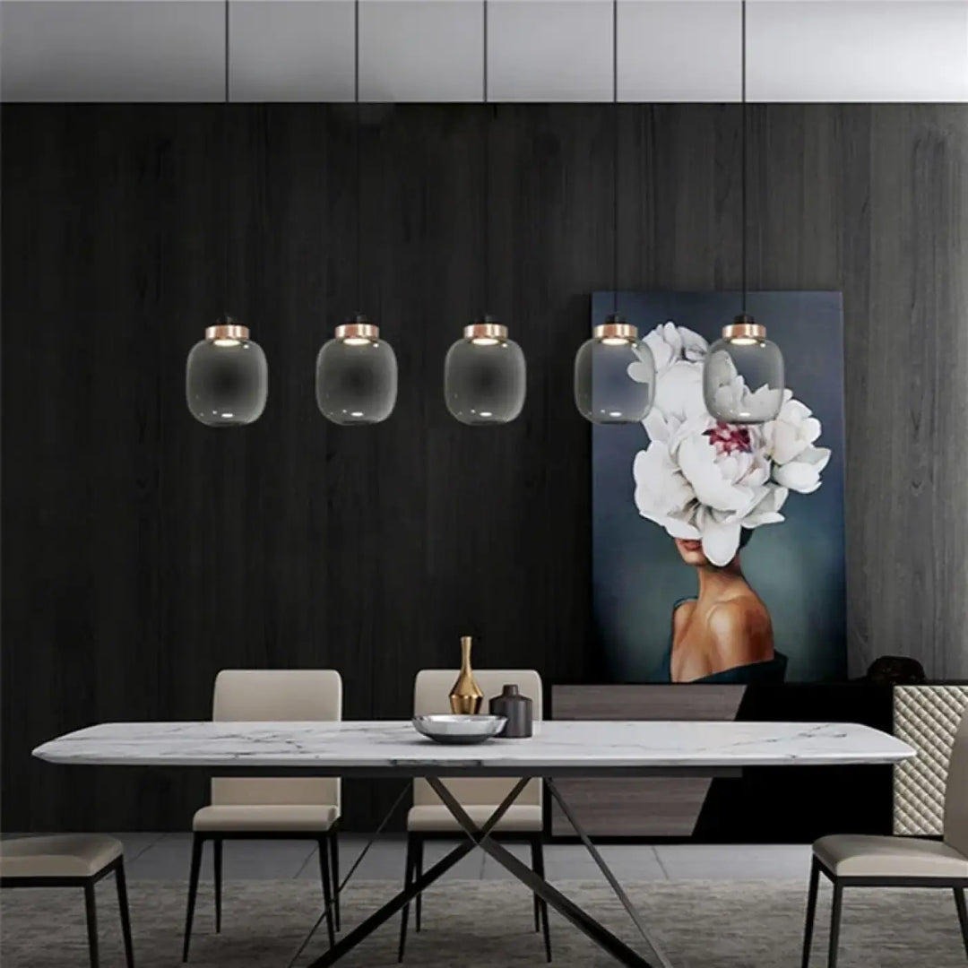 Suspension luminaire mistral avec cinq suspensions en verre gris fumé et accents en laiton au-dessus dune table en marbre