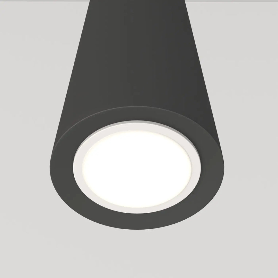 Suspension luminaire neVill cône étroit en acier noir avec finition mate et centre lumineux blanc au-dessus d’un espace