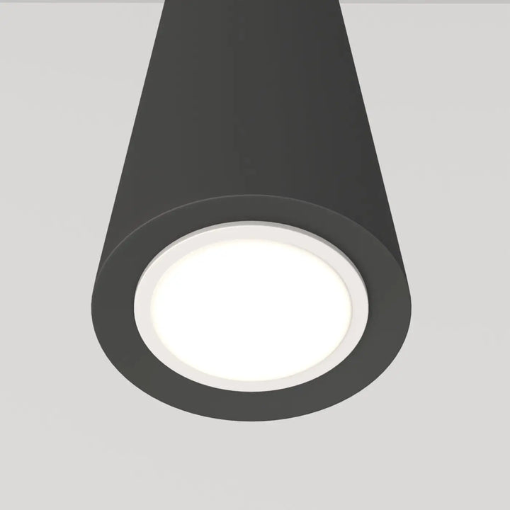 Suspension luminaire neVill cône étroit en acier noir avec finition mate et centre lumineux blanc au-dessus d’un espace