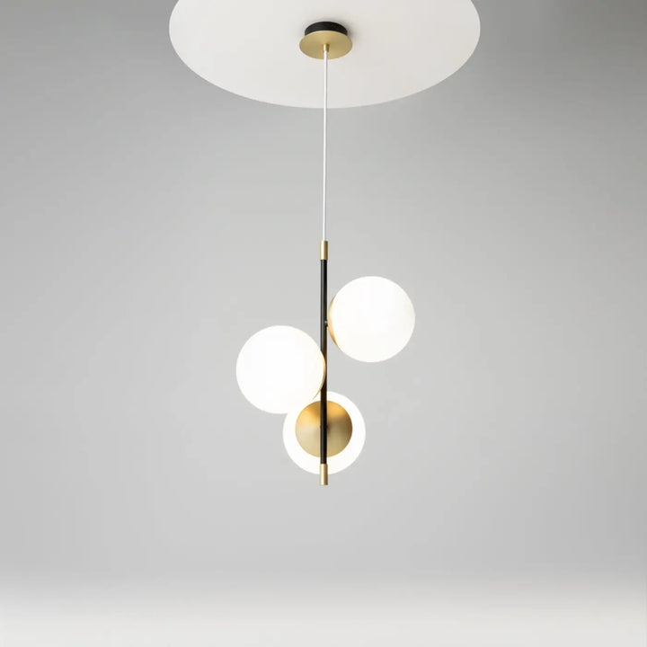 Suspension luminaire nostalgia trois globes avec globes en verre opalin et accents en acier noir et laiton