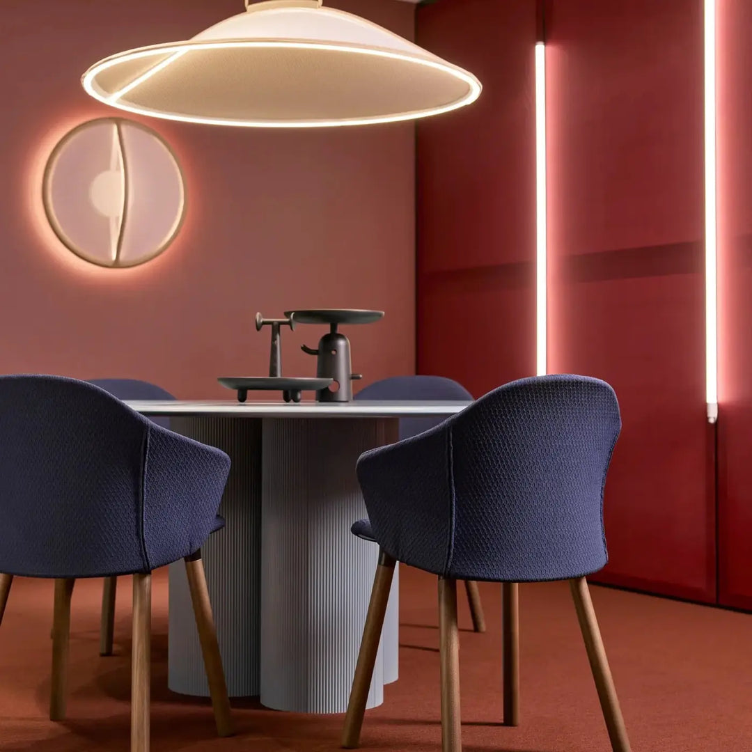 Modern navy blue woven fabric dining chairs with slender wooden legs complement lumière douce pendant by patricia urquiola tricot tendu