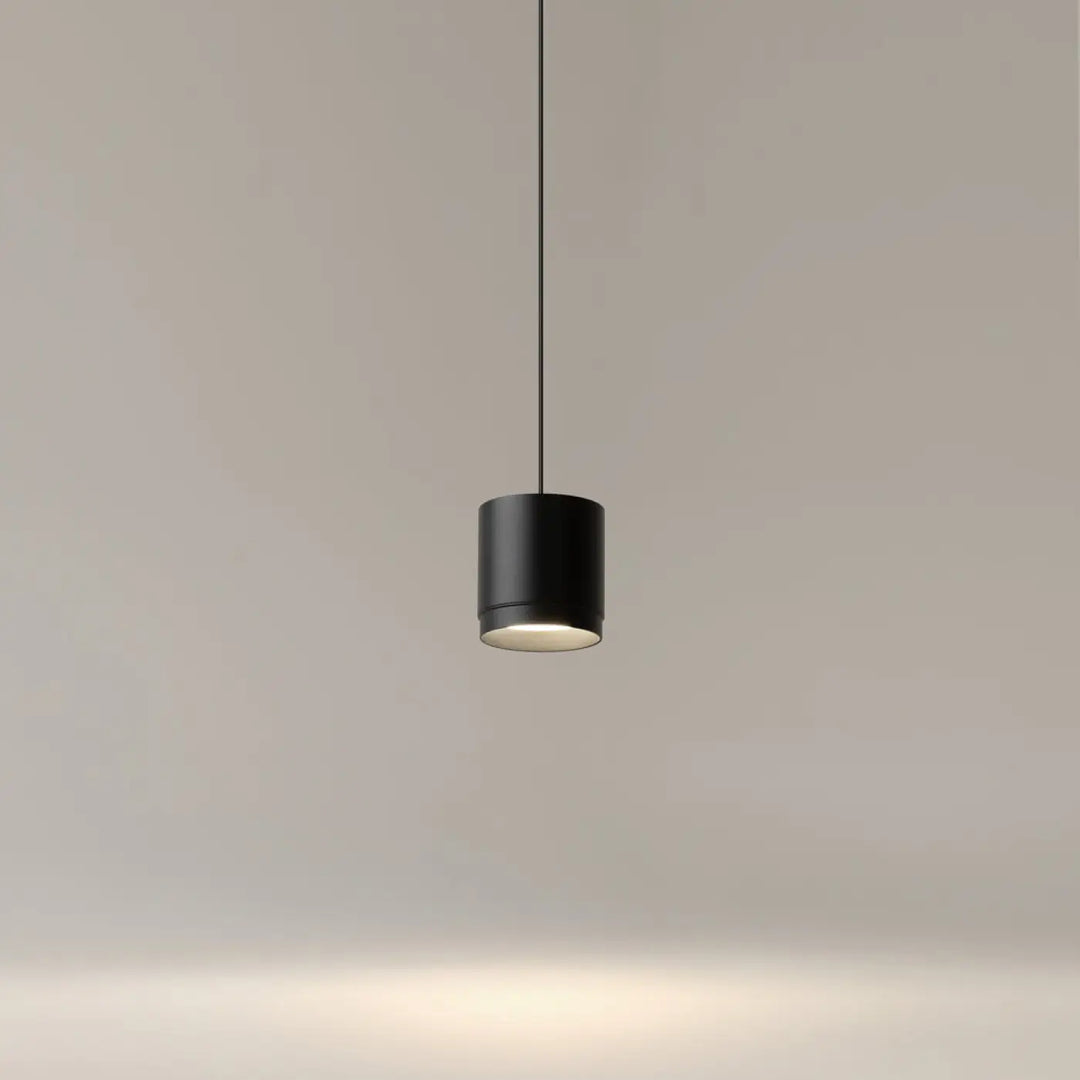 Suspension polar petit disque noire cylindrique avec design minimaliste et lumière chaude à la base éclairée