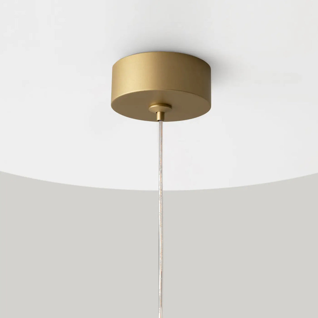 Suspension luminaire polar petit disque cylindrique doré avec design minimaliste et cordon métallique fin