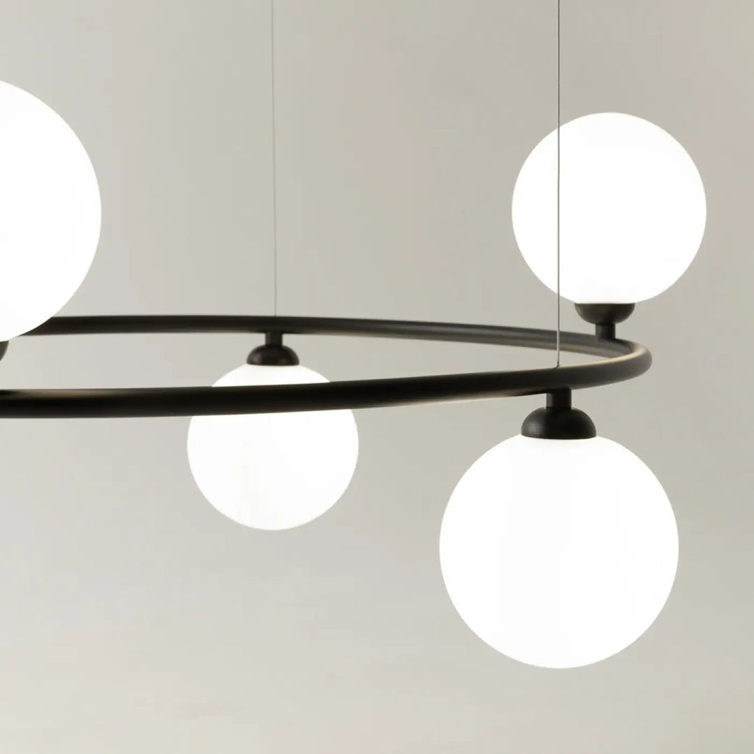 Suspension ring en métal noir moderne avec quatre globes en verre blanc éclairés touche art déco