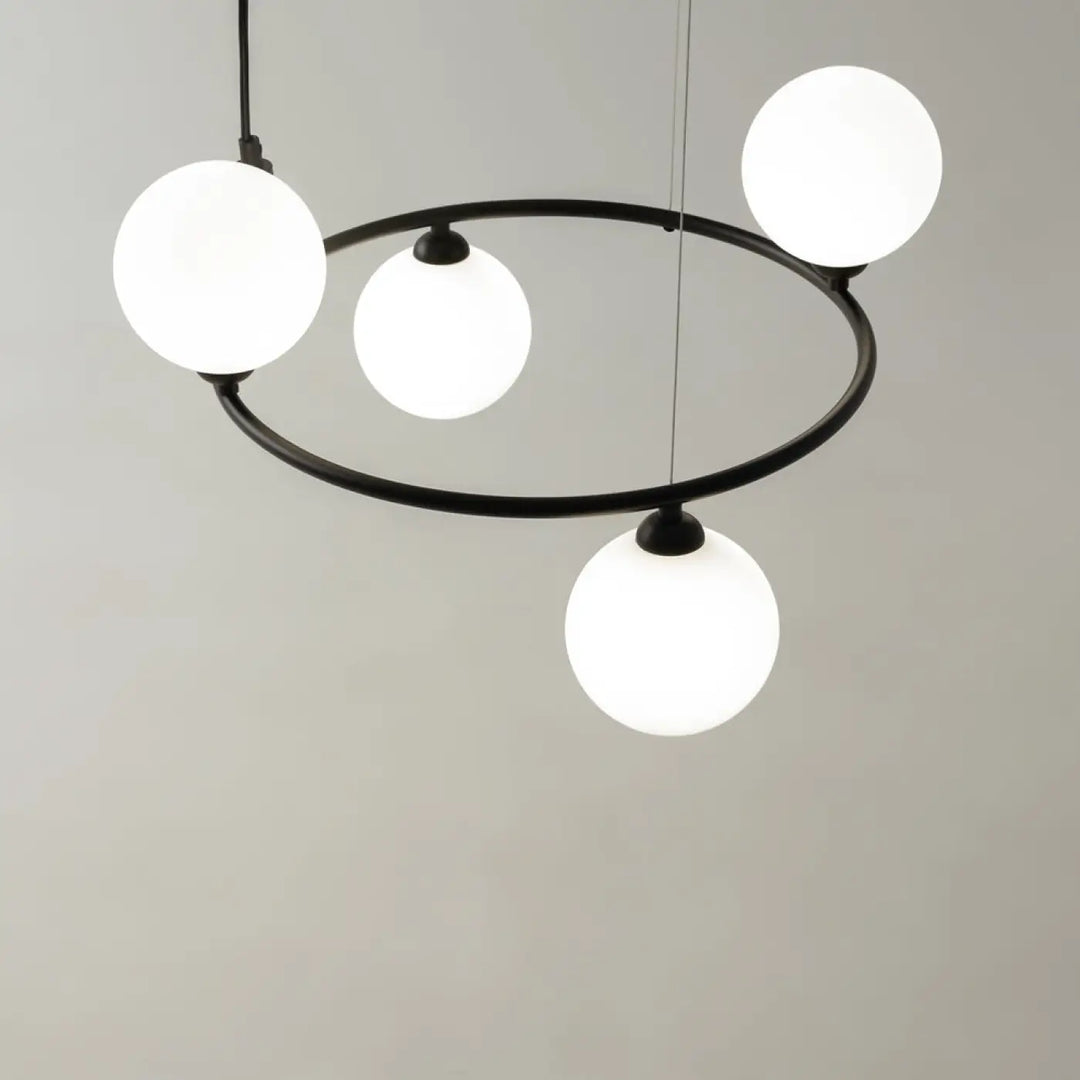 Suspension ring noire en métal moderne avec quatre globes en verre dépoli blanc pour une touche art déco