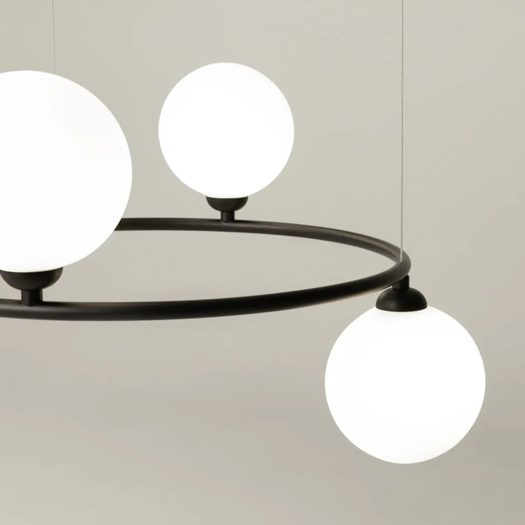 Suspension ring en métal noir moderne avec trois globes en verre dépoli blanc pour une touche art déco élégante