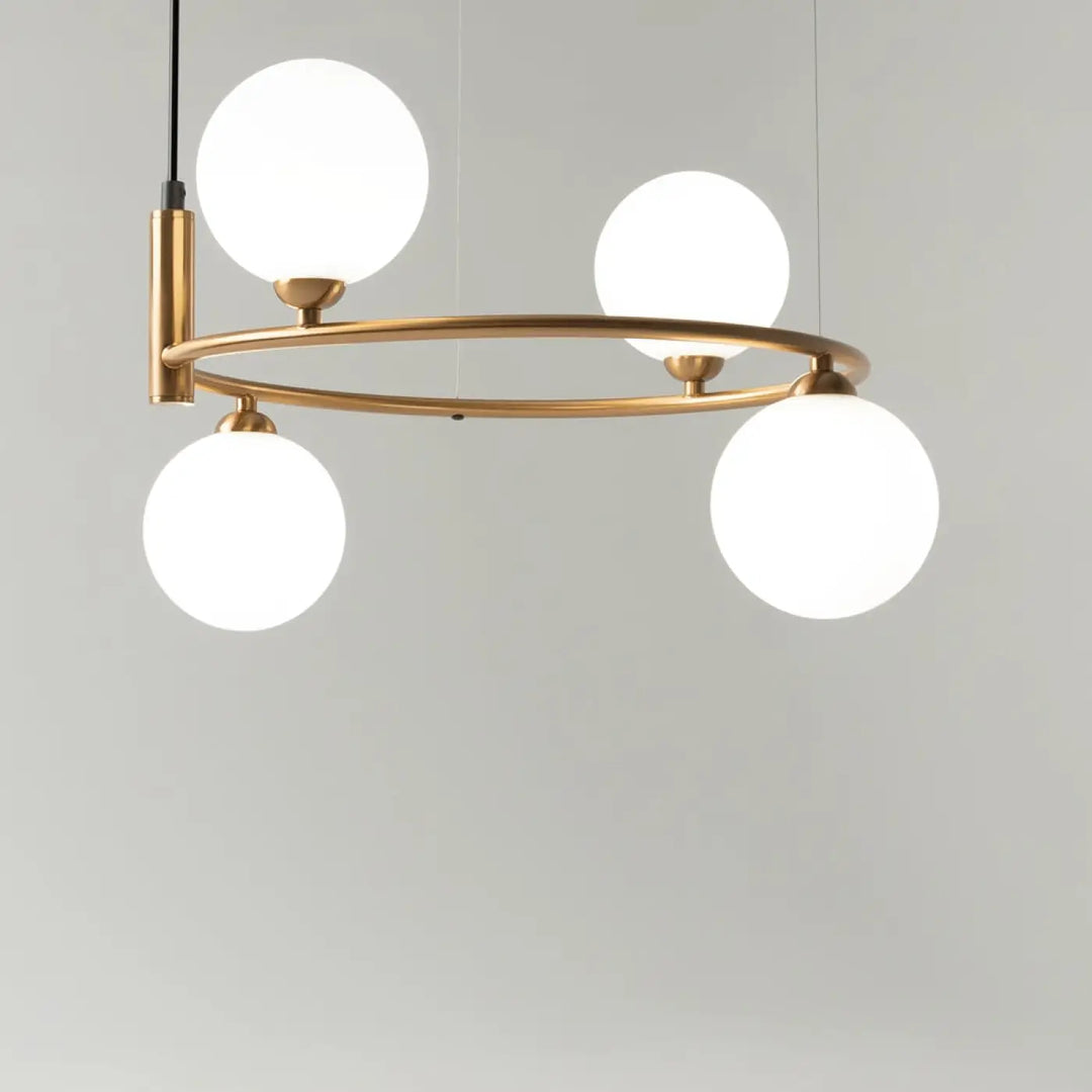 Suspension ring en laiton moderne avec quatre globes en verre givré pour une touche art déco élégante