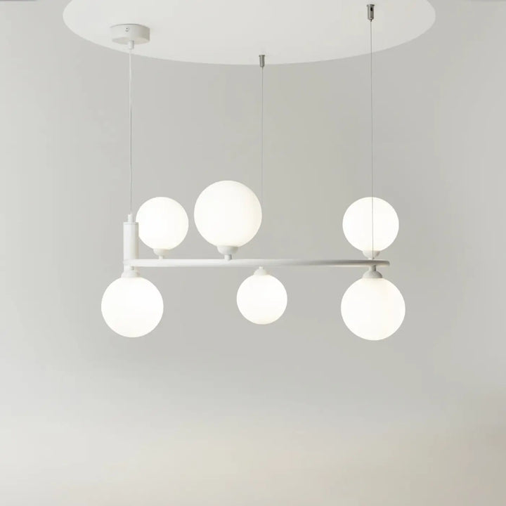 Suspension ring moderne blanche avec six globes en verre dépoli disposés en ligne pour une touche art déco
