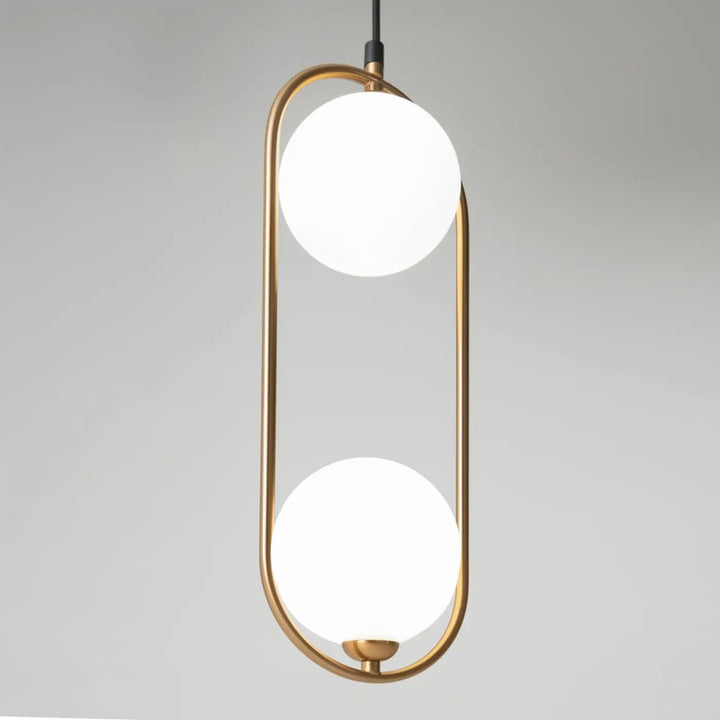 Suspension ring art déco avec deux globes en verre dépoli suspendus dans un cadre ovale en laiton au-dessus d’un îlot