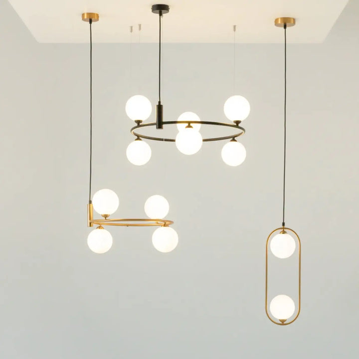 Suspension ring art déco avec cadre métal noir et or et globes en verre dépoli idéale au-dessus d’un îlot