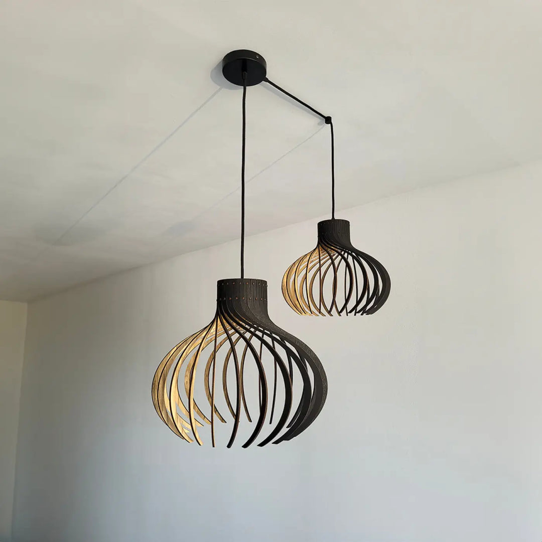 Suspension luminaire rinoz piatoni avec deux suspensions modernes en bois courbé noir pour cage d’escalier