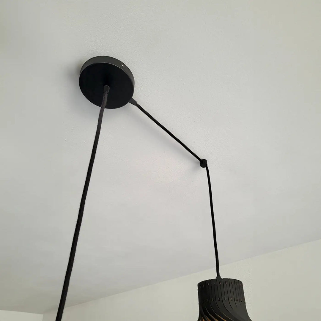 Suspension luminaire rinoz piatoni noire avec montage circulaire et abat-jour cylindrique en matériau stratifié pour cage d’escalier